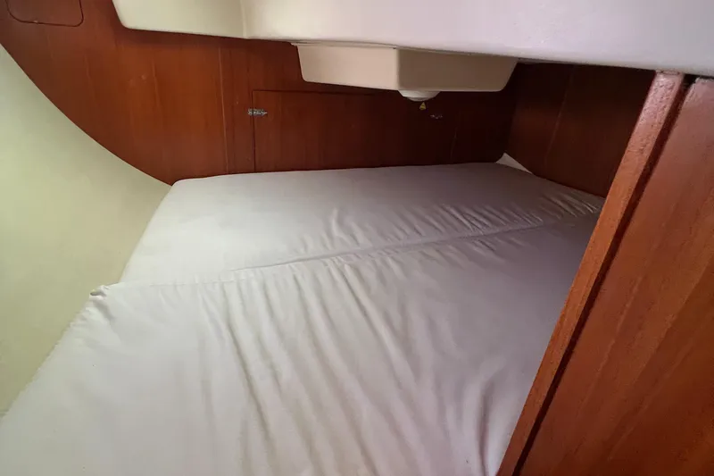Slide: The Image of Interior cabin of a 2005 Hunter 33 sailboat with a neatly made bed. - 9