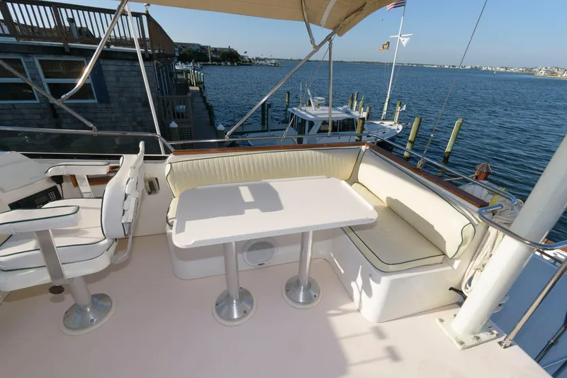 Slide: The Image of 2000 Sabreline 47 Motor Yacht deck with seating and table, overlooking marina. - 10