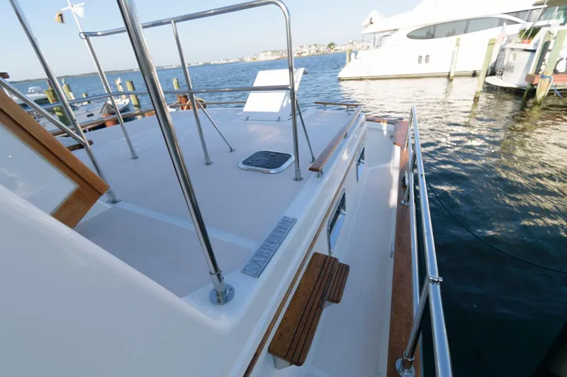 Slide: The Image of 2000 Sabreline 47 Motor Yacht deck with railing, overlooking marina waters. - 12