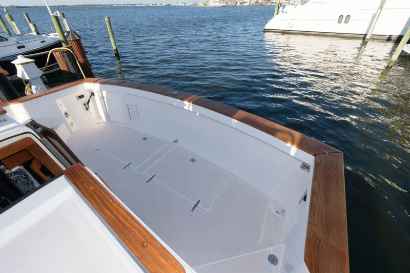 Slide: The Image of Sabreline 47 Motor Yacht 2000, spacious deck, wooden trim, docked on calm water. - 13