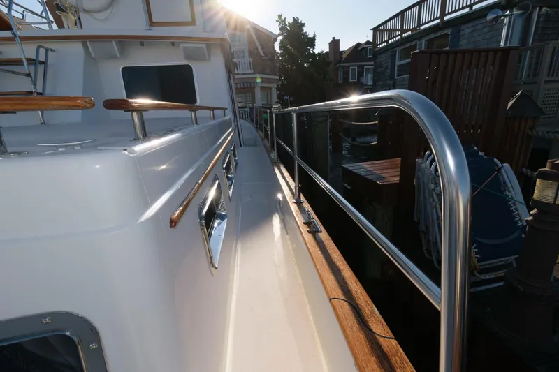 Slide: The Image of Side view of 2000 Sabreline 47 Motor Yacht with sunlit deck and railing. - 16