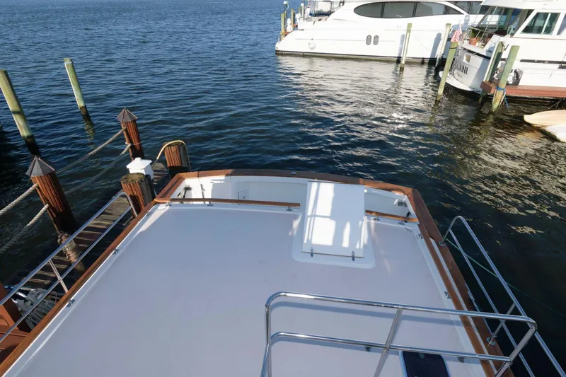 Slide: The Image of Sabreline 47 Motor Yacht 2000 docked, showcasing spacious deck and serene waterfront view. - 18