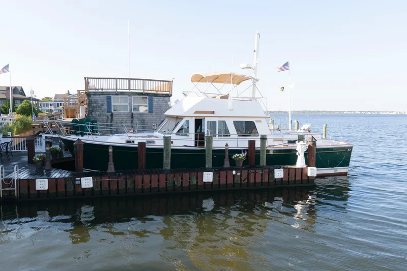 Slide: The Image of 2000 Sabreline 47 Motor Yacht docked by waterfront homes. - 2