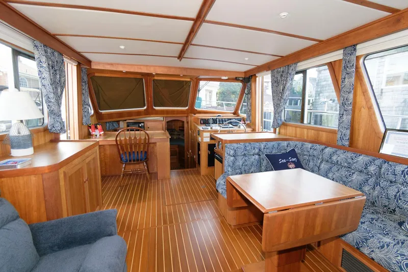 Slide: The Image of Interior of 2000 Sabreline 47 Motor Yacht with wooden furnishings and blue patterned upholstery. - 21