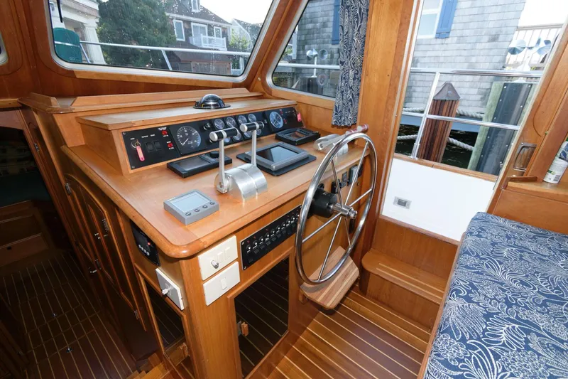 Slide: The Image of 2000 Sabreline 47 Motor Yacht helm with wooden dashboard and steering wheel. - 27