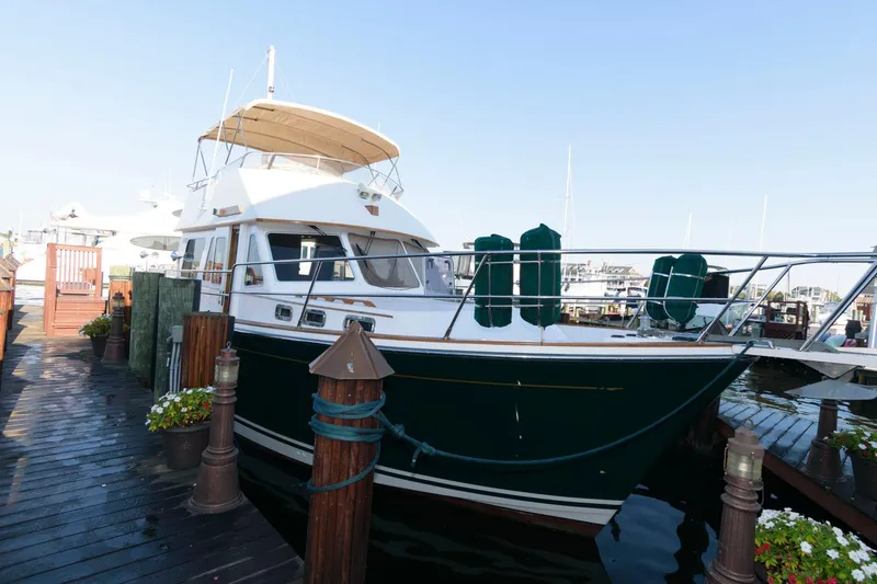 Slide: The Image of Sabreline 47 Motor Yacht 2000 docked at marina, featuring sleek design and spacious deck. - 3