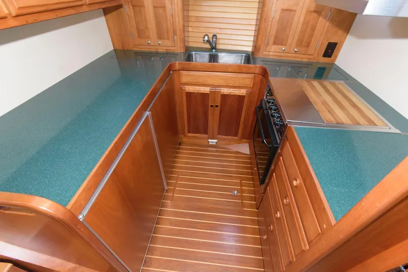 Slide: The Image of Galley kitchen in 2000 Sabreline 47 Motor Yacht with wood cabinetry and green countertops. - 30
