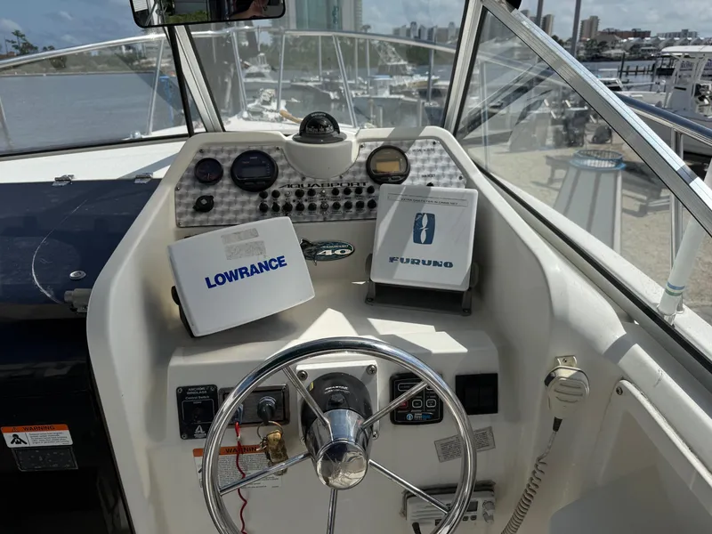 Slide: The Image of 2004 Aquasport 250 Explorer boat dashboard with Lowrance and Furuno navigation systems. - 10