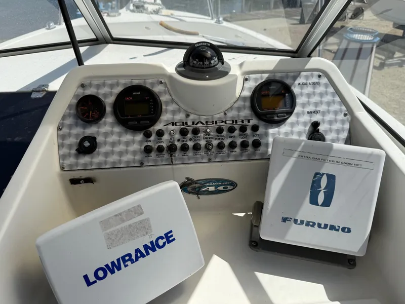 Slide: The Image of 2004 Aquasport 250 Explorer dashboard with Lowrance and Furuno navigation equipment. - 11