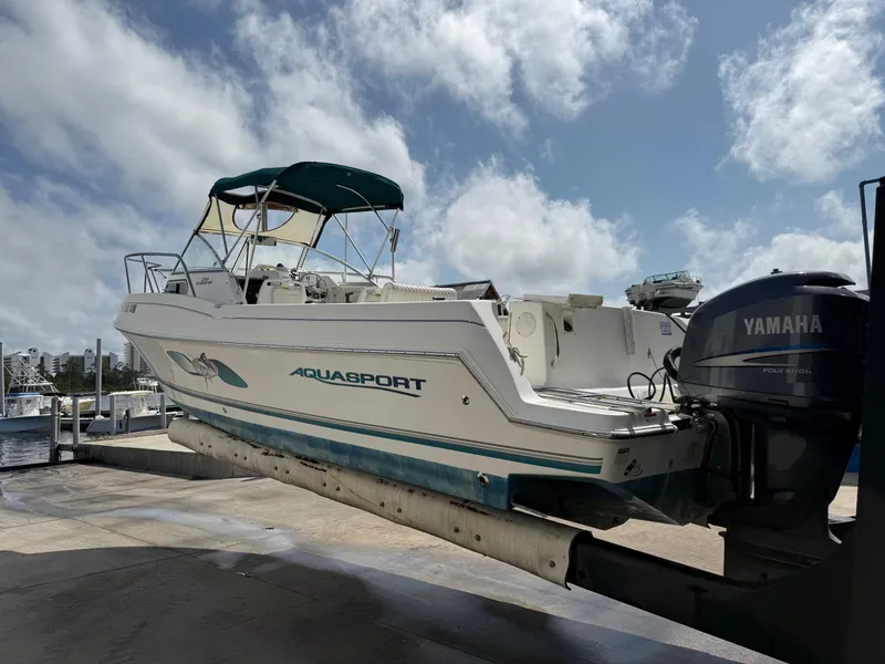 Slide: The Image of 2004 Aquasport 250 Explorer boat with Yamaha outboard motor on a lift. - 13