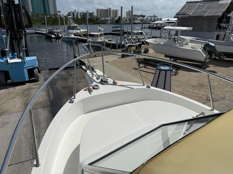 Slide: The Image of 2004 Aquasport 250 Explorer boat docked at a marina with cityscape background. - 23