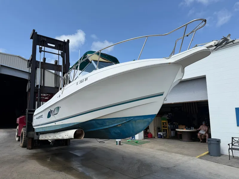 Slide: The Image of 2004 Aquasport 250 Explorer boat lifted by forklift near a warehouse. - 3