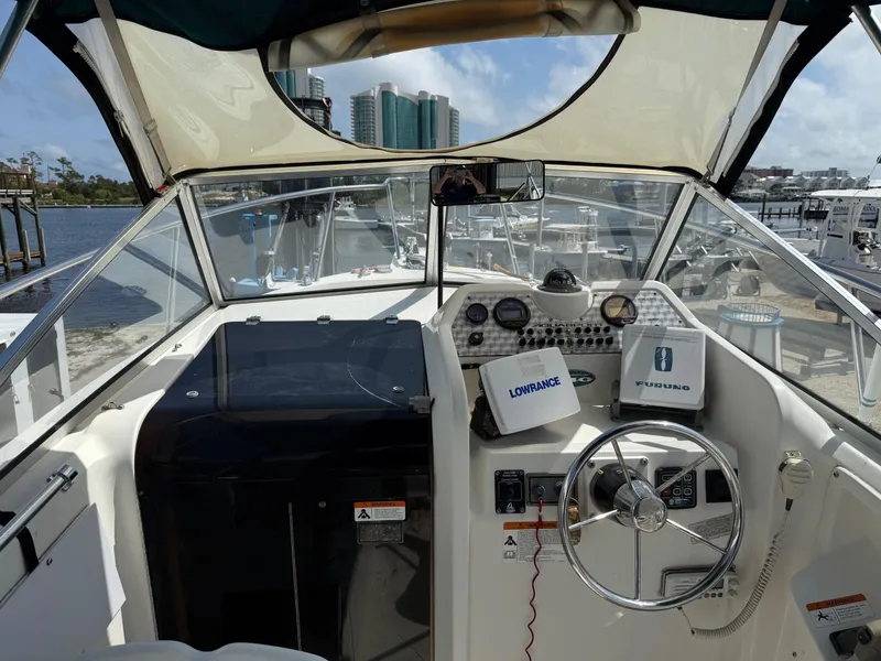 Slide: The Image of 2004 Aquasport 250 Explorer boat cockpit with steering wheel and navigation equipment. - 9