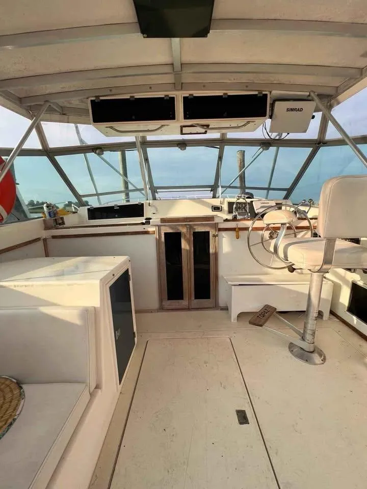 Slide: The Image of 1988 Topaz 37 Sportfisherman boat interior with helm, seating, and ocean view. - 2