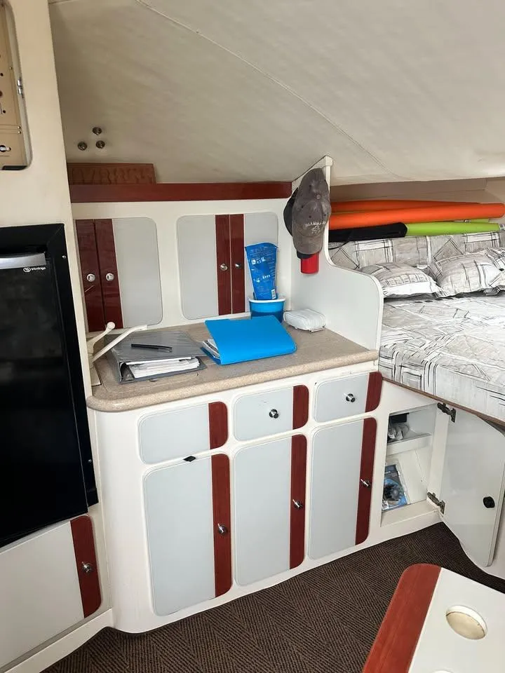 Slide: The Image of Interior of a 1997 Phoenix 32 Tournament boat with cabinets and a cozy sleeping area. - 9