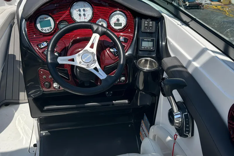 Slide: The Image of 2018 Rinker 26QX BR boat dashboard with steering wheel and control panel. - 6