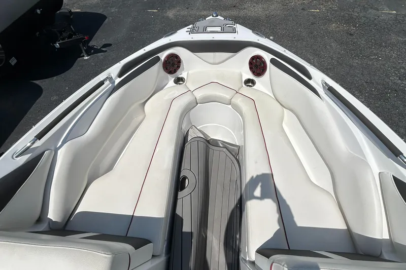Slide: The Image of 2018 Rinker 26QX BR boat interior with white seating and speakers. - 9