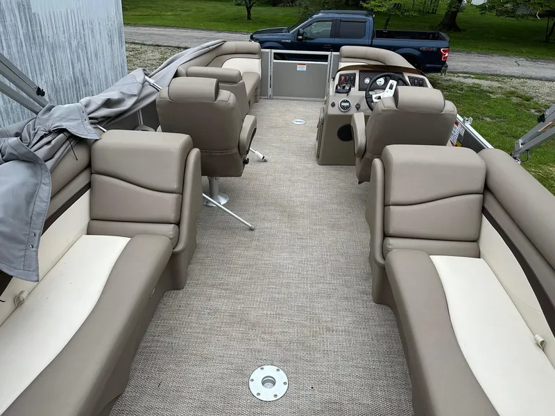 Slide: The Image of 2019 Bennington 22 SSR Quad Bench interior with beige seating and steering console. - 11