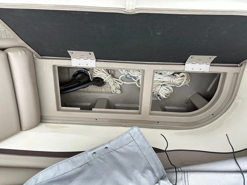 Slide: The Image of 2019 Bennington 22 SSR Quad Bench storage compartment with ropes and cover. - 12
