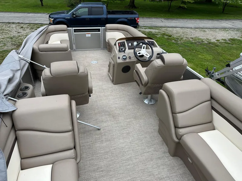 Slide: The Image of 2019 Bennington 22 SSR Quad Bench interior with beige seating and steering console. - 13