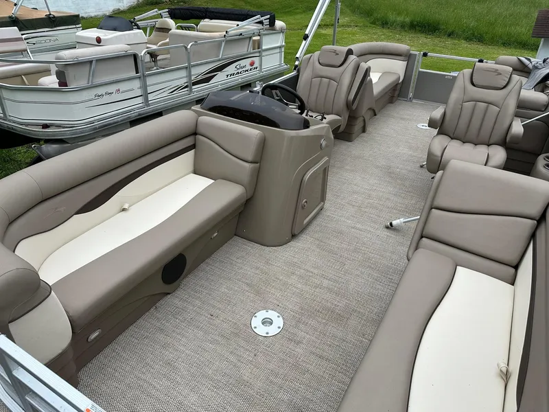 Slide: The Image of 2019 Bennington 22 SSR Quad Bench pontoon boat interior with plush seating and steering console. - 5
