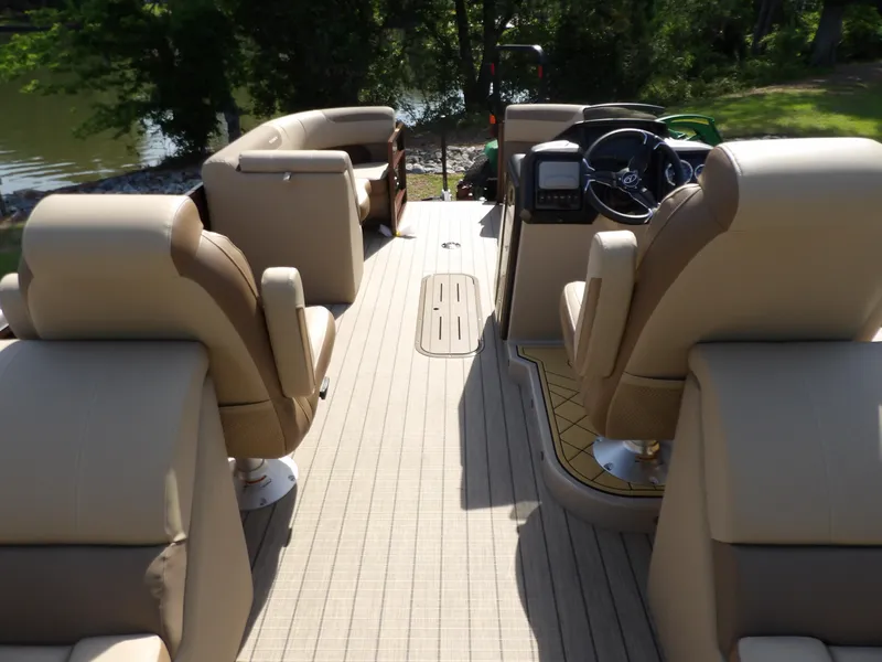 Slide: The Image of 2025 Veranda VR22RC pontoon boat interior with beige seating and steering console. - 13