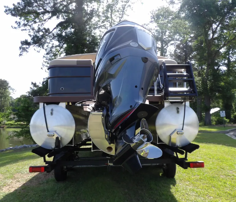 Slide: The Image of 2025 Veranda VR22RC pontoon boat with powerful outboard motor, parked on grassy area. - 4