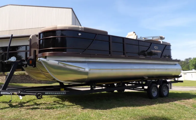 Slide: The Image of 2025 Veranda VR22RC pontoon boat on trailer, parked outdoors near a building. - 9