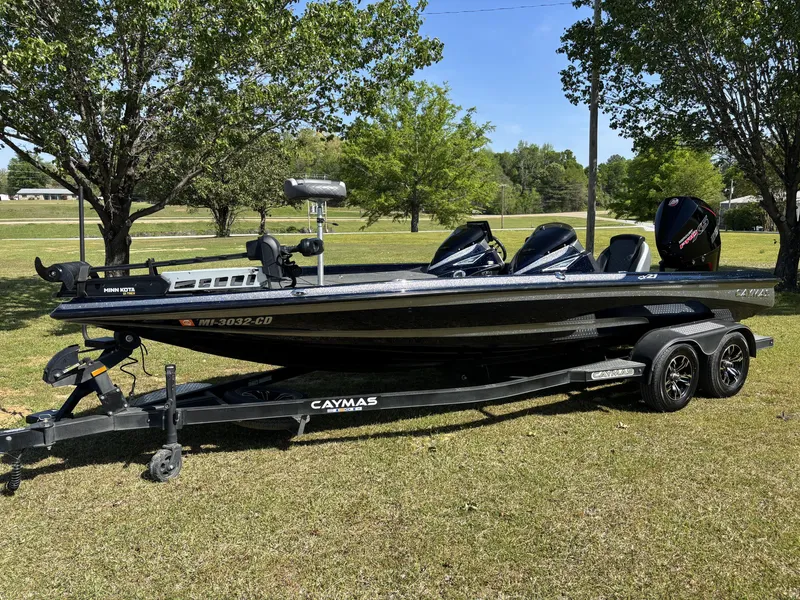 Slide: The Image of 2022 Caymas CX21 Pro boat on trailer, parked on grass with trees in background. - 10