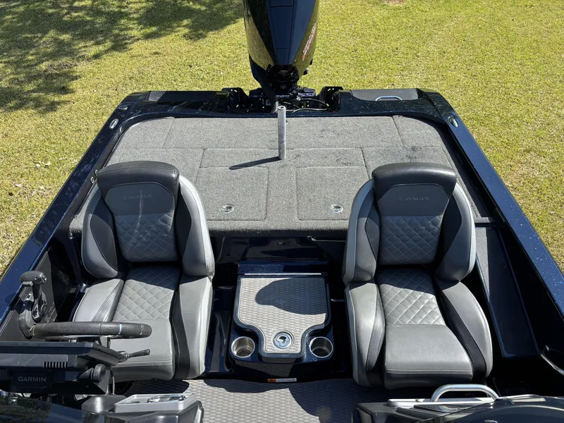 Slide: The Image of 2022 Caymas CX21 Pro boat interior with dual seats and console on grassy background. - 17