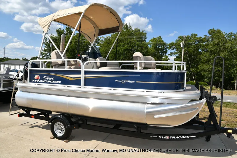 Slide: The Image of 2025 Sun Tracker Bass Buggy 16 XL Select pontoon boat on trailer, outdoor display. - 41