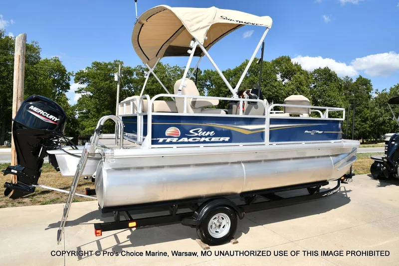 Slide: The Image of 2025 Sun Tracker Bass Buggy 16 XL Select pontoon boat on trailer, with Mercury outboard motor. - 8