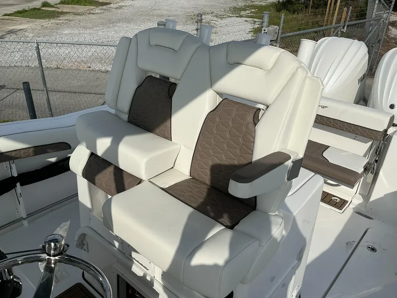 Slide: The Image of 2025 Tidewater 282CC boat seats with white and brown upholstery, featuring armrests and modern design. - 15