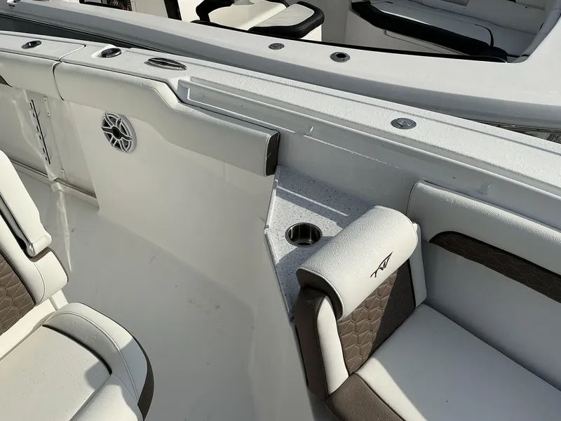 Slide: The Image of 2025 Tidewater 282CC boat interior with cushioned seating and cup holder. - 22