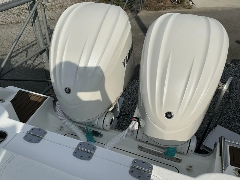 Slide: The Image of Twin Yamaha outboard engines on a 2025 Tidewater 282CC boat, docked on gravel. - 24