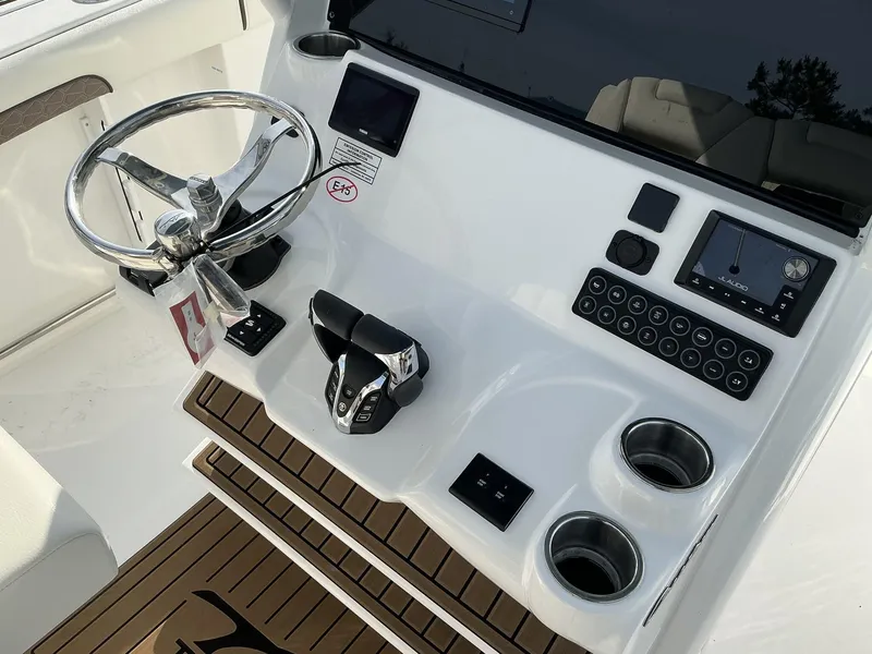 Slide: The Image of 2025 Tidewater 282CC boat dashboard with steering wheel, controls, and cup holders. - 28