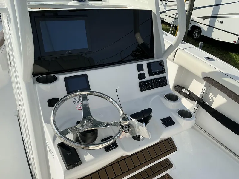 Slide: The Image of 2025 Tidewater 282CC boat console with steering wheel, digital displays, and cup holders. - 12