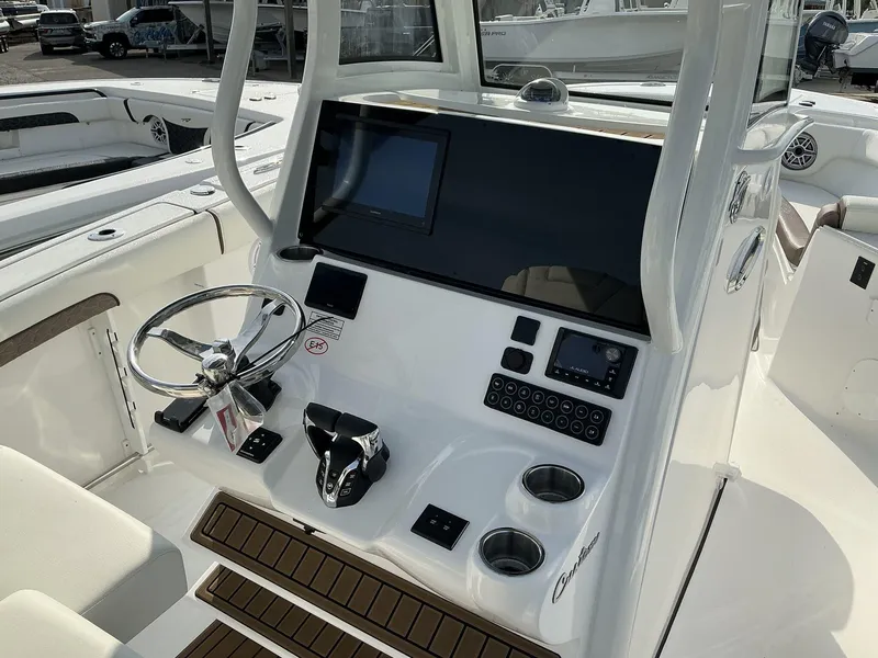 Slide: The Image of 2025 Tidewater 282CC boat console with steering wheel, controls, and display screen. - 25