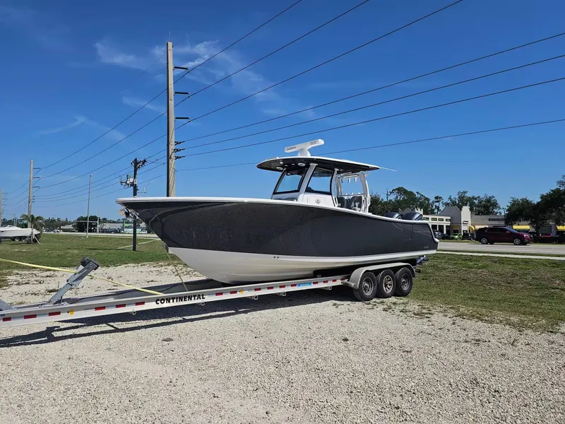 Slide: The Image of 2021 Sportsman 302 CC boat on trailer under clear blue sky. - 2