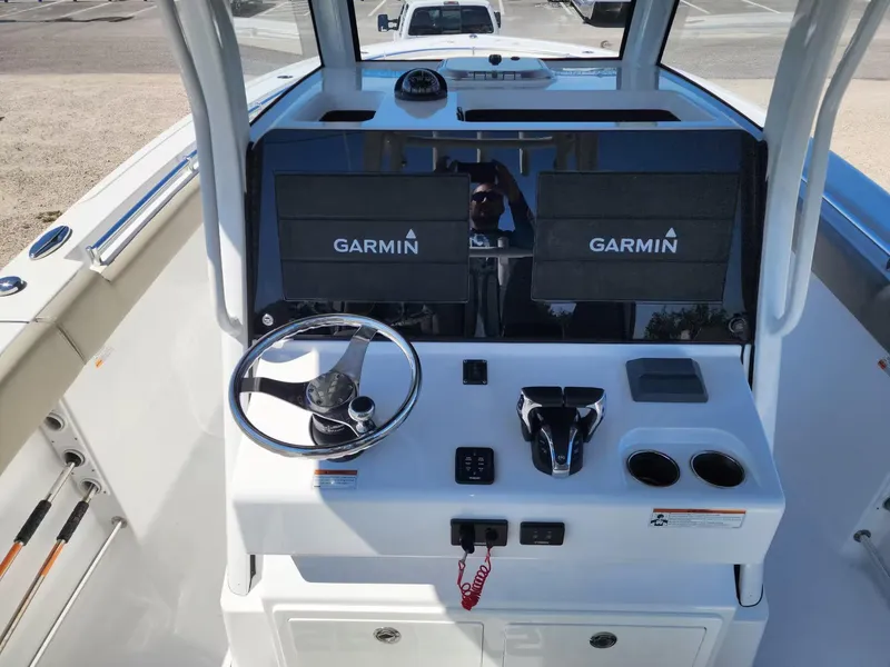 Slide: The Image of 2021 Sportsman 302 CC boat dashboard with Garmin displays and steering wheel. - 4