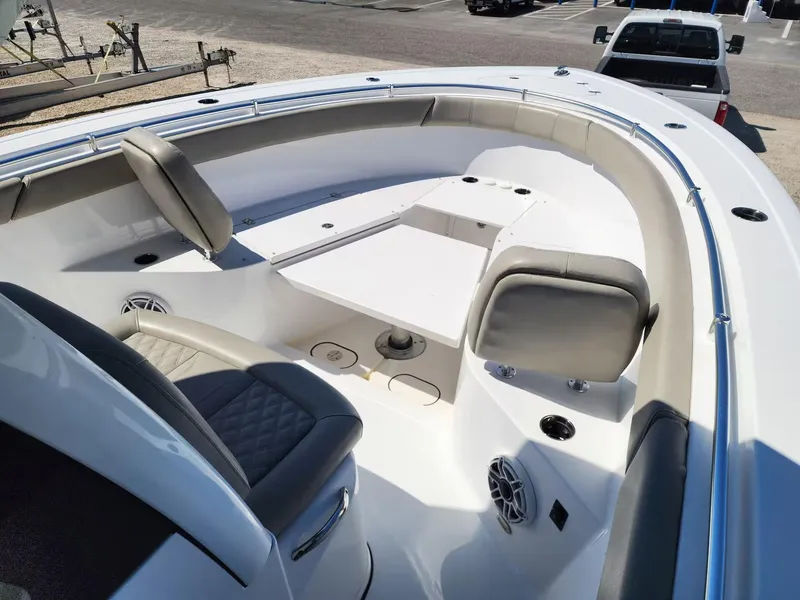 Slide: The Image of 2021 Sportsman 302 CC boat interior with seating and table, parked near a truck. - 5