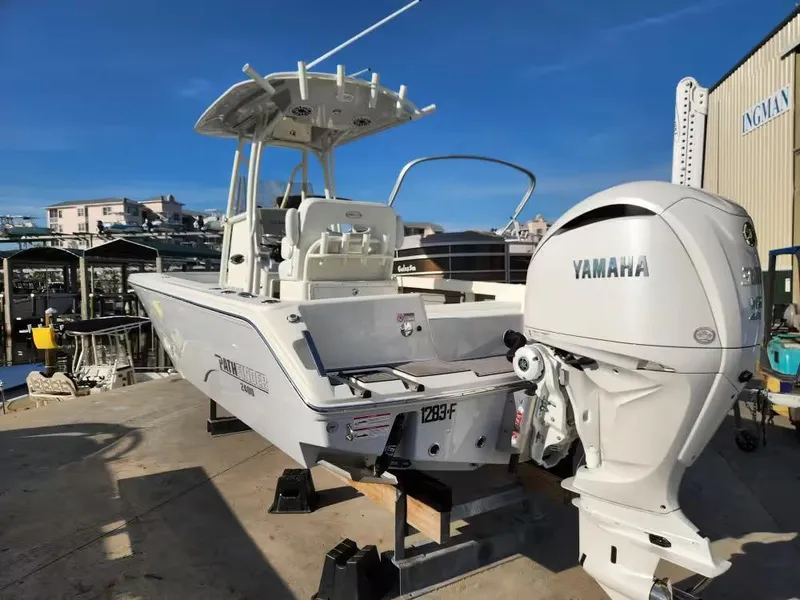 Slide: The Image of 2024 Pathfinder 2400 TRS boat with Yamaha engine, docked at marina under clear blue sky. - 4