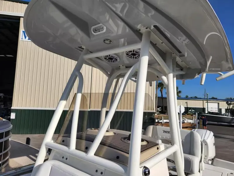 Slide: The Image of 2024 Pathfinder 2400 TRS boat with T-top and speakers, docked near a warehouse. - 5