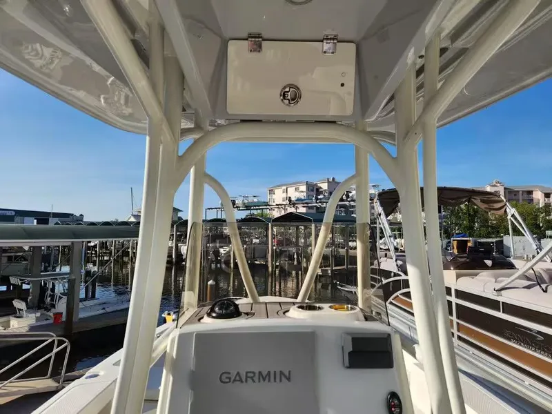 Slide: The Image of 2024 Pathfinder 2400 TRS boat interior with Garmin equipment, docked at a marina. - 6
