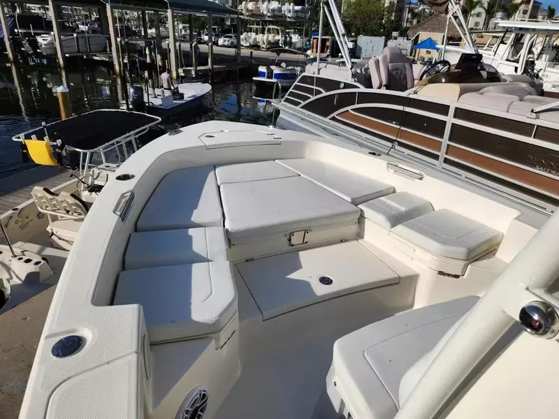 Slide: The Image of 2024 Pathfinder 2400 TRS boat with spacious seating at a marina. - 9