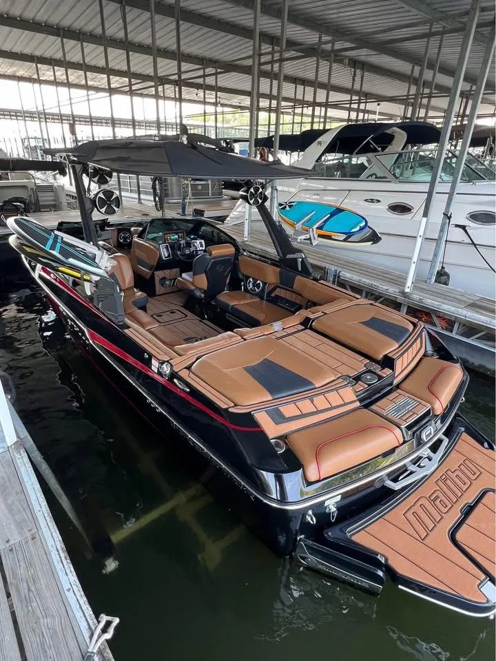 Slide: The Image of 2021 Malibu Wakesetter 23 MXZ boat docked, featuring sleek design and luxurious seating. - 3