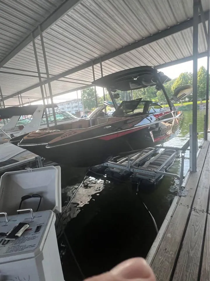 Slide: The Image of 2021 Malibu Wakesetter 23 MXZ boat docked under a covered marina. - 5