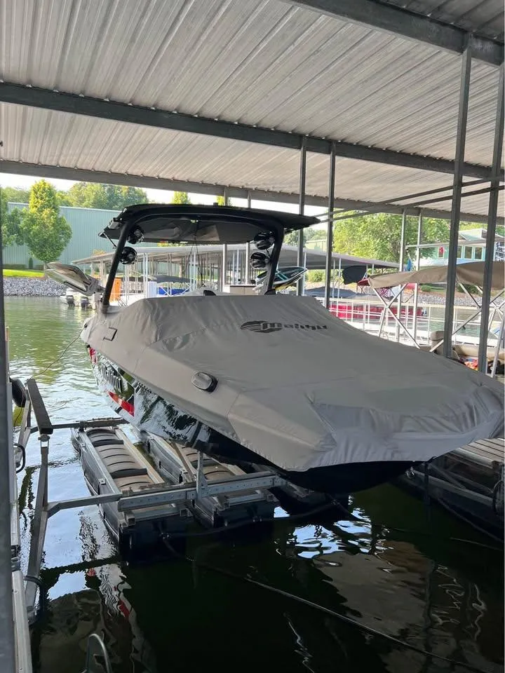 Slide: The Image of 2021 Malibu Wakesetter 23 MXZ boat covered and docked in a marina. - 6