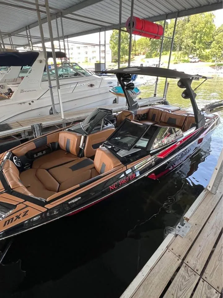 Slide: The Image of 2021 Malibu Wakesetter 23 MXZ boat docked in a marina, featuring sleek design and spacious seating. - 7