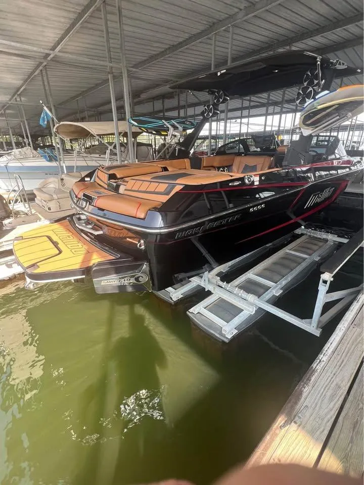 Slide: The Image of 2021 Malibu Wakesetter 23 MXZ boat docked in a covered marina. - 8